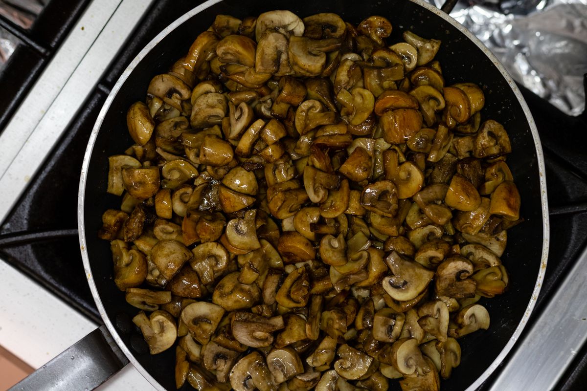 Overhead view of savory sauteed mushrooms cooked down in a skillet
