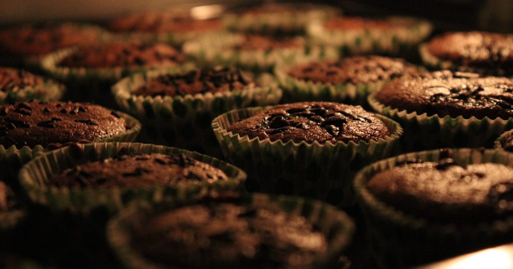 A pan of freshly baked spiced breakfast muffins cooling in a metal tin