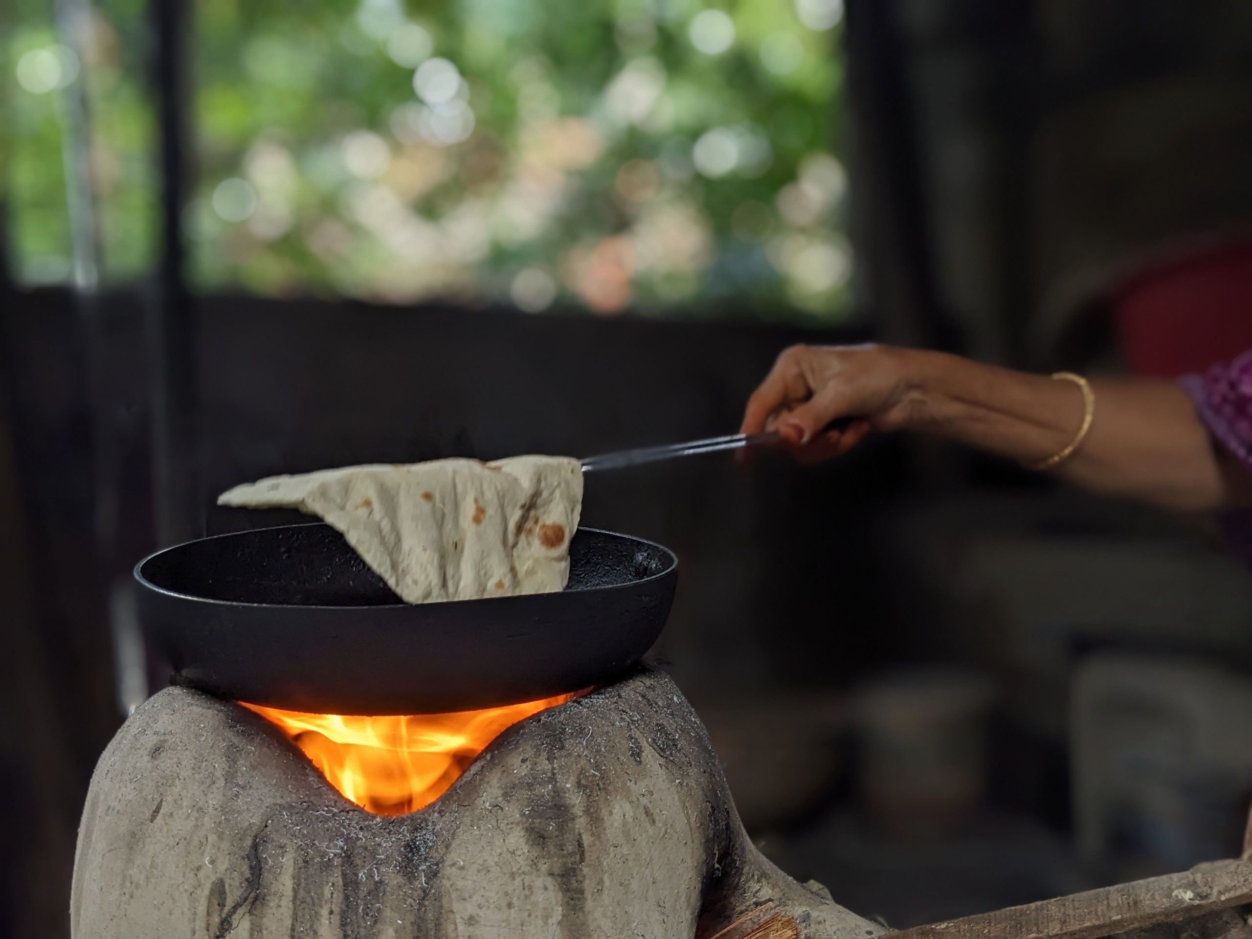 Homemade flatbread cooking on an open flame griddle, rustic method