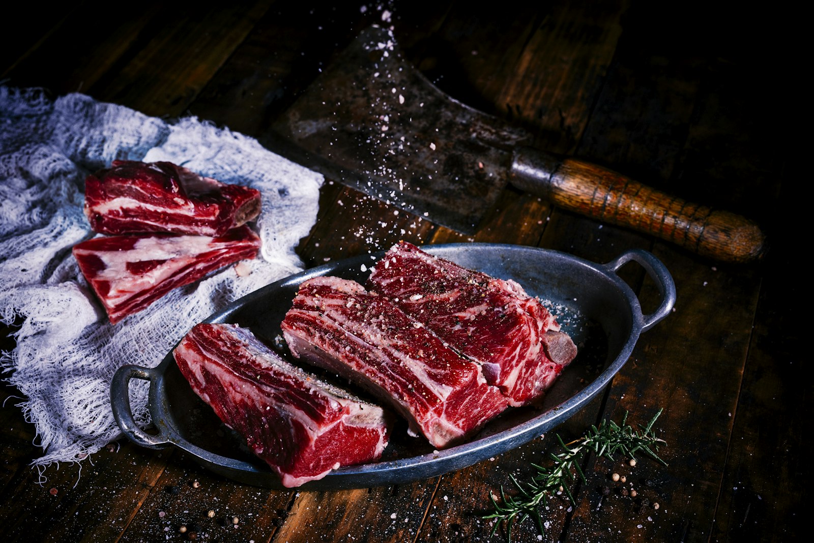Thinly sliced raw beef prepped on a wooden cutting board