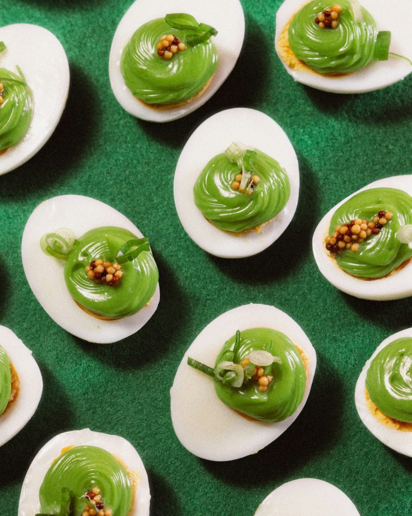 Avocado deviled eggs with green filling and mustard seeds