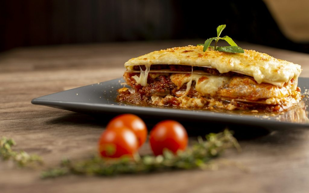 Slice of beef lasagna with melted cheese on a plate