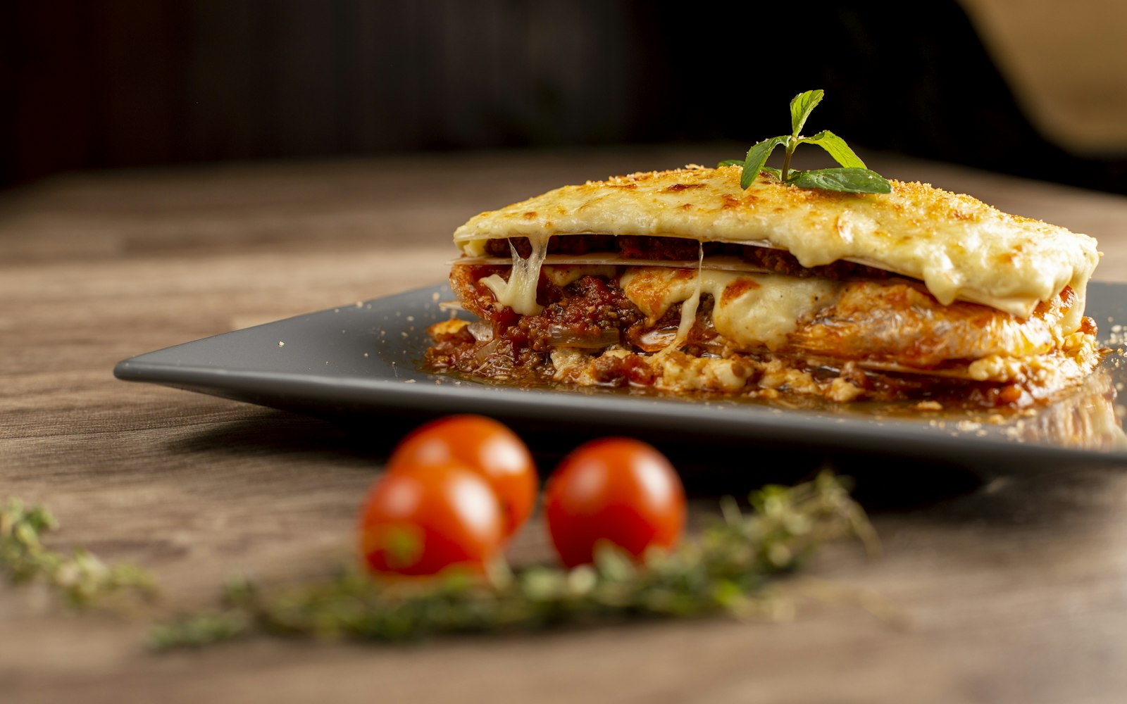 Slice of beef lasagna with melted cheese on a plate