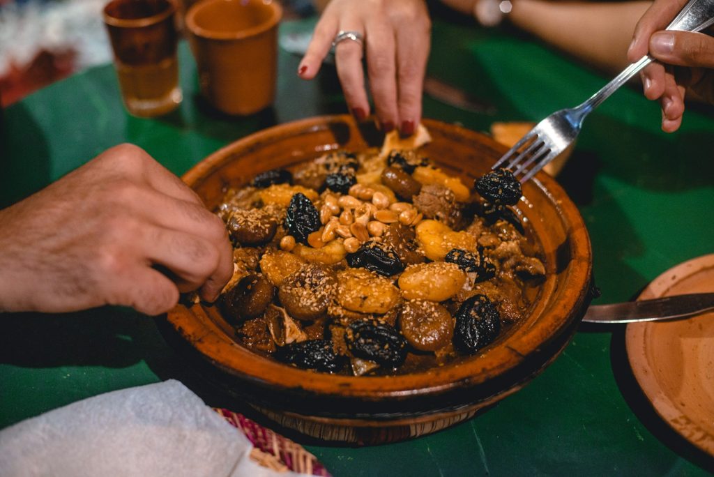 Moroccan beef tagine with prunes and almonds served in a clay tagine