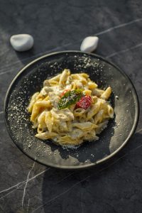Chicken alfredo pasta with penne and parmesan on a dark plate