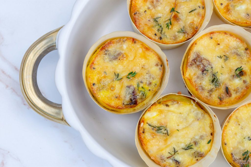 Cottage cheese egg bites topped with melted cheese on a white plate