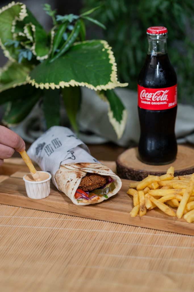 Falafel wrap with vegetables and sauce served with fries