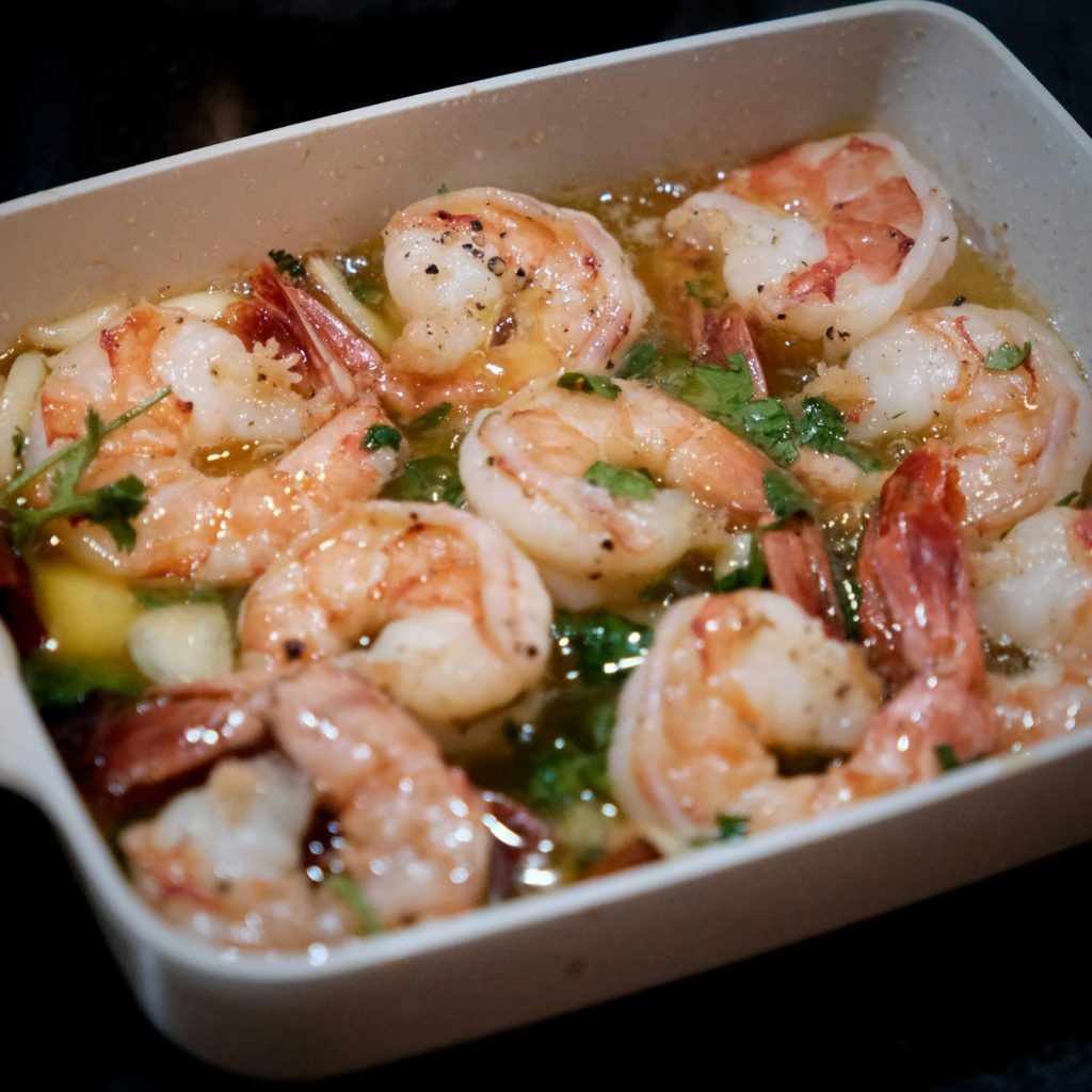 Garlic butter shrimp with parsley in a white baking dish