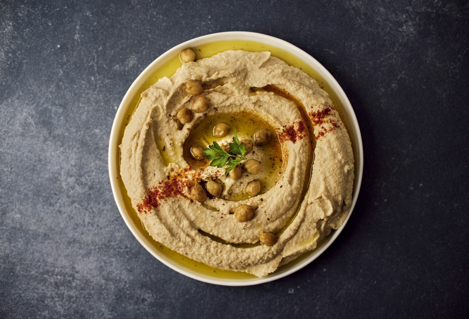 Homemade hummus with olive oil, chickpeas and paprika in a bowl