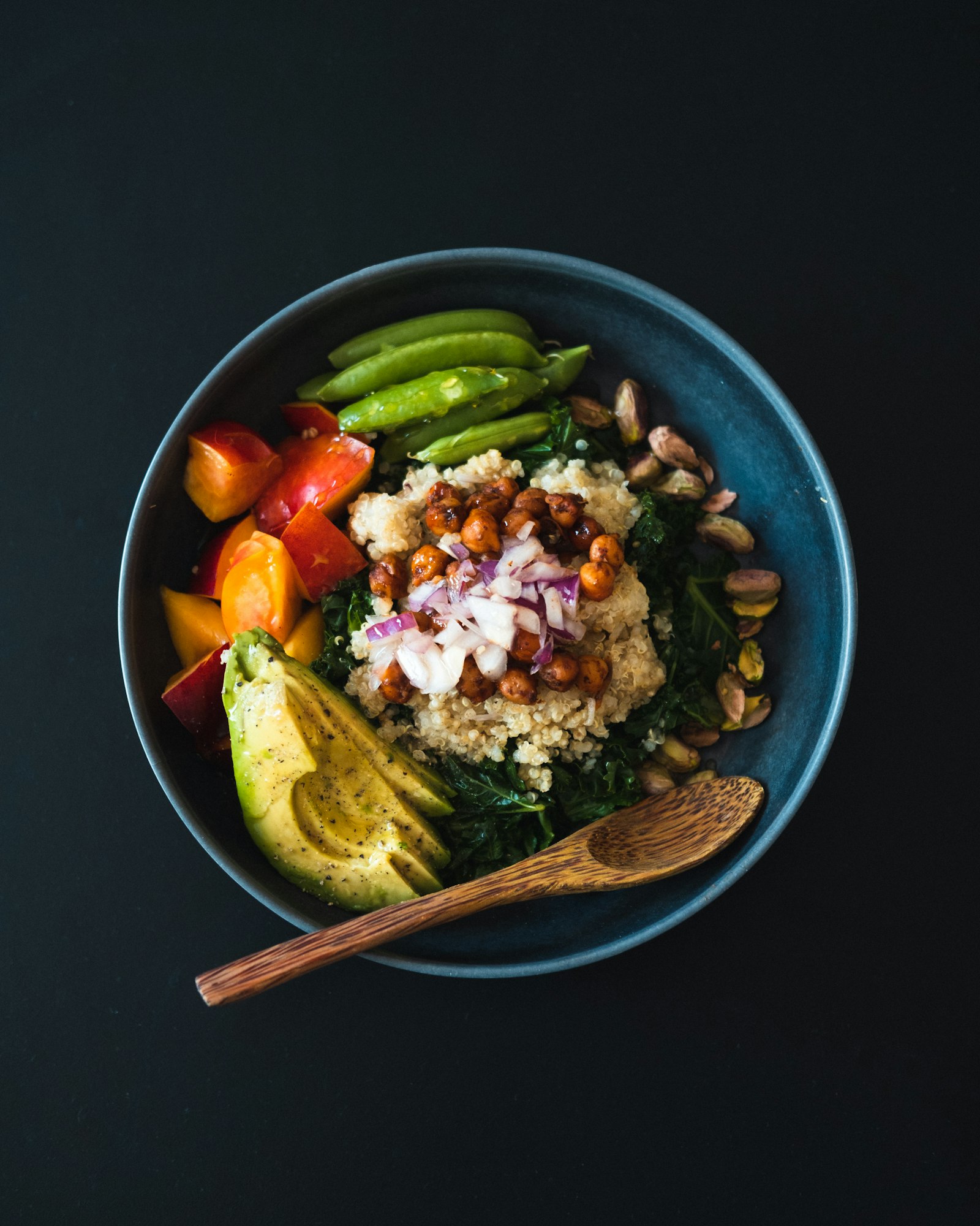 Quinoa power bowl with kale, chickpeas, avocado, tomatoes and pistachios