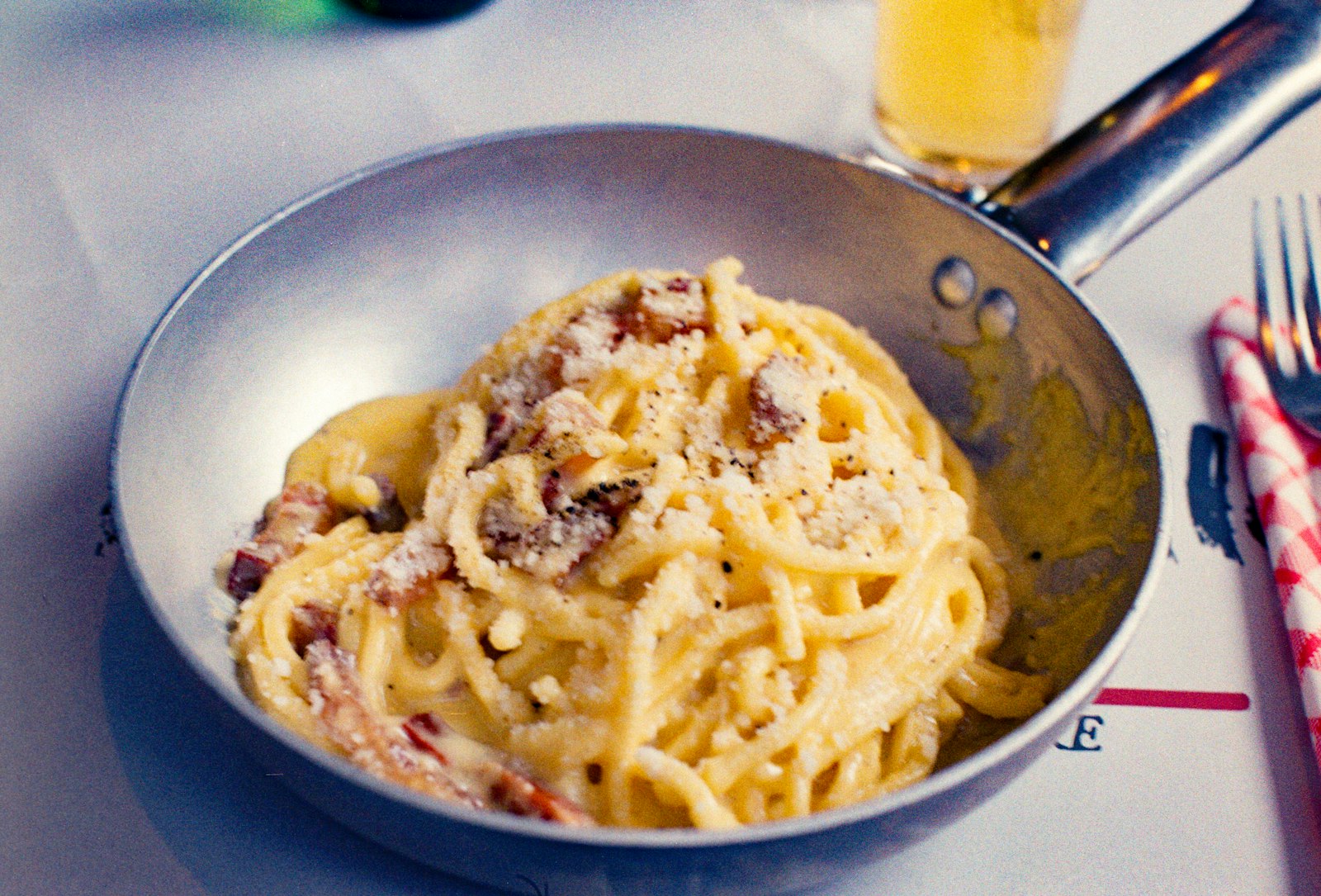 Spaghetti carbonara with crispy guanciale and pecorino in a pan