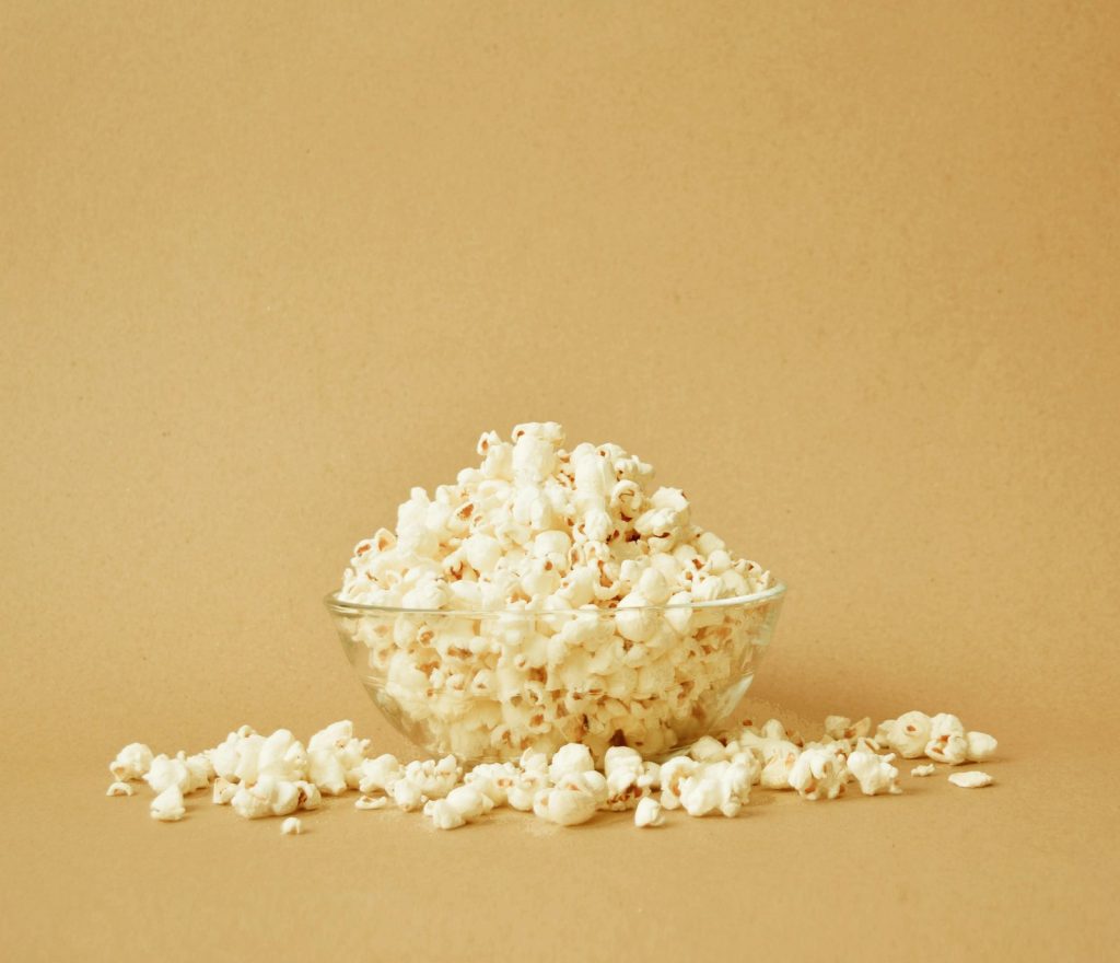 Bowl of stovetop popcorn on a beige background