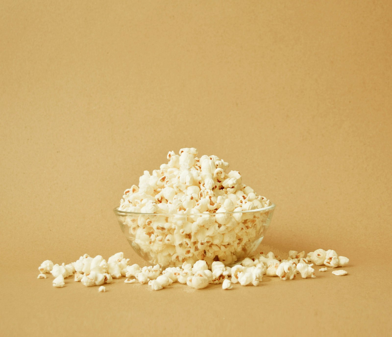 Bowl of stovetop popcorn on a beige background
