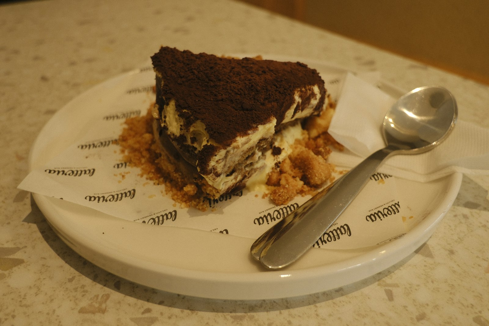Slice of tiramisu cheesecake dusted with cocoa powder