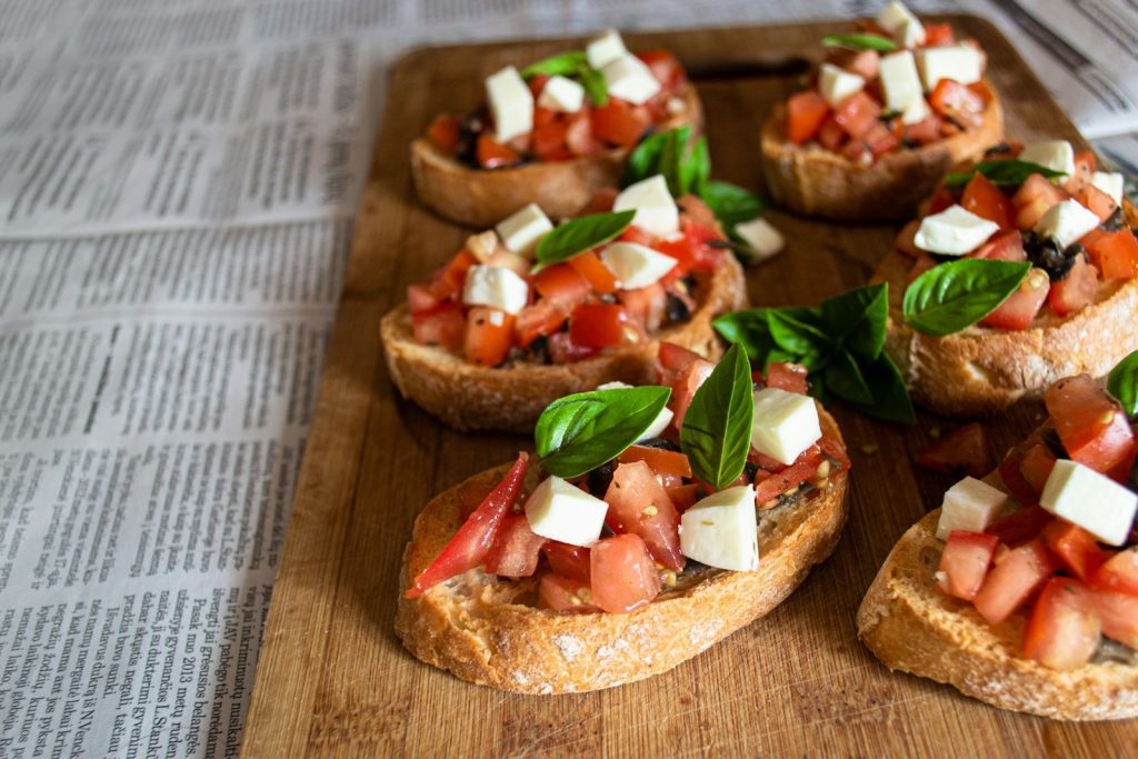 Tomato bruschetta with mozzarella and basil on a wooden board